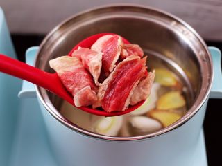 番茄牛肉炖土豆,东菱早餐机的汤锅里，加入适量的清水，先加入料酒，再放入葱花和姜片煮沸后，把切块的牛肉放入锅中。