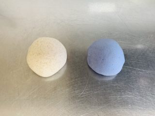 蓝天白云全麦小馒头,首先，制作白色面团，糖、酵母、水放在小碗中调匀，把调好的酵母水一点一点地加入到全麦粉中，揉至光滑面团，放入保鲜盒中放至风干。（这里强调一下这款小馒头是一次性发酵，所以面团一定要揉至光滑、细腻到扩展阶段）
用同样的方法制作蓝色面团：取80克的碟豆花水，与糖、酵母混合均匀，加入到全麦面粉中，揉至光滑面团。