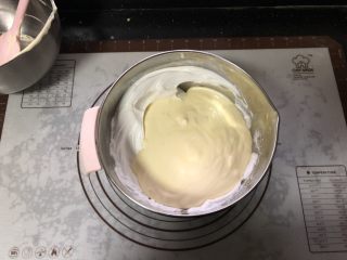 橙香戚风蛋糕,把翻拌好的蛋糕糊倒入到剩下的一半蛋白霜中。