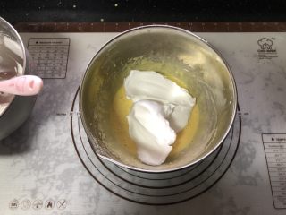 橙香戚风蛋糕,取一半蛋白霜放在蛋黄糊中。