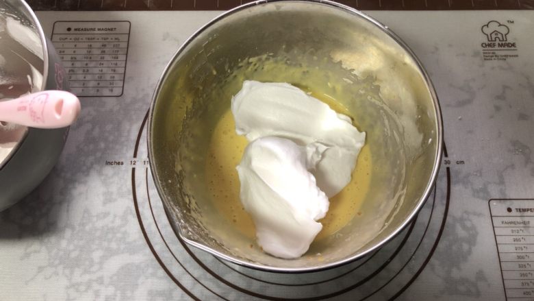 橙香戚风蛋糕,取一半蛋白霜放在蛋黄糊中。
