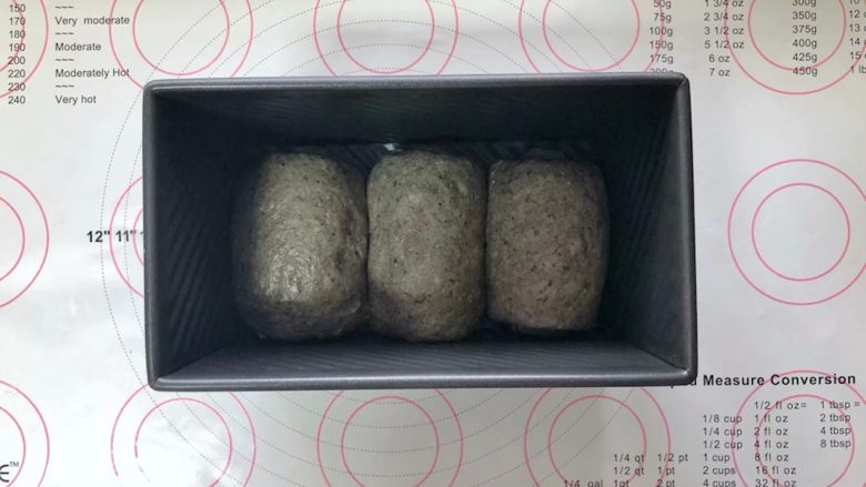 黑芝麻吐司(一次发酵）,收口朝下码入吐司盒中，盖上保鲜膜室温下进行发酵。