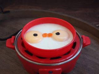 创意儿童辅食～蒸鸡蛋,小心打开蒸蛋器的盖儿。
将圆形的胡萝卜做嘴巴，海苔做鱼的眼睛装饰一下。