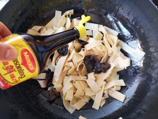 韭香豆腐皮,再加入适量的味极鲜酱油翻炒均匀。