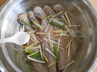椒盐鳎米鱼,将处理好的鳎米鱼放在容器中，加入葱姜丝，加适量的盐。
