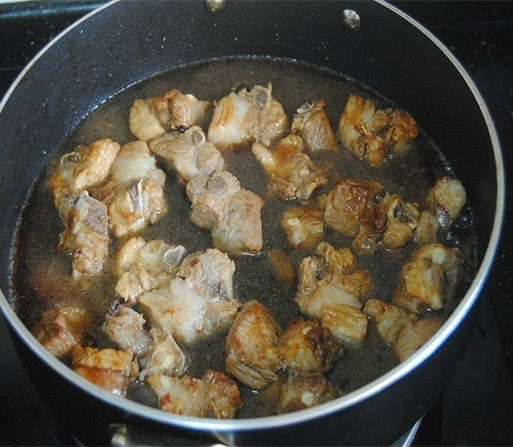 土豆烧排骨,倒入没过排骨一半的清水，盖上锅盖焖煮10分钟；