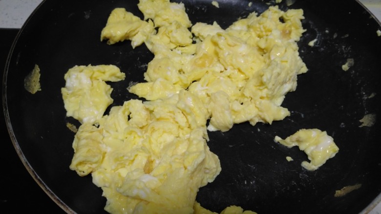 韭菜鸡蛋水煎包,锅中放入适量油，倒入鸡蛋，定型后翻动。