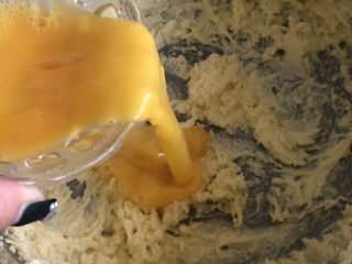 红薯曲奇饼干,待黄油颜色明显变浅，质地变蓬松似奶油状，加入一半的蛋液，继续打发。