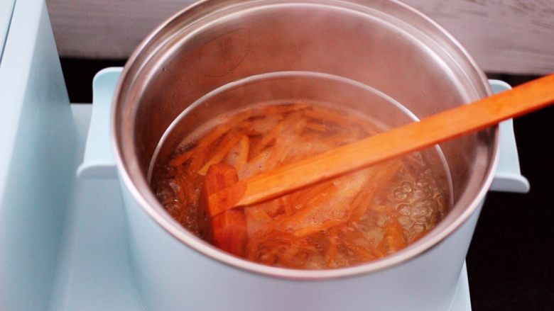 鹅蛋菠菜早餐饼,东菱早餐机的汤锅里，加入适量的清水煮沸后，加入切丝的胡萝卜焯一下水。