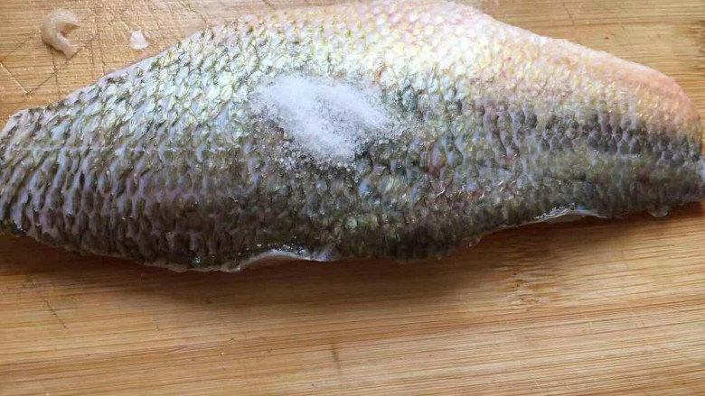 健康低卡香煎鲈鱼,鱼的正反两面用盐腌制。