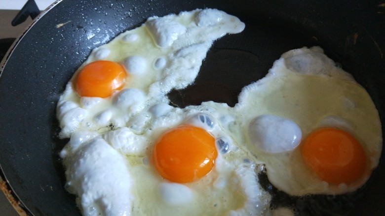 荷包蛋炒虾仁,鸡蛋三个打入平底锅煎制。