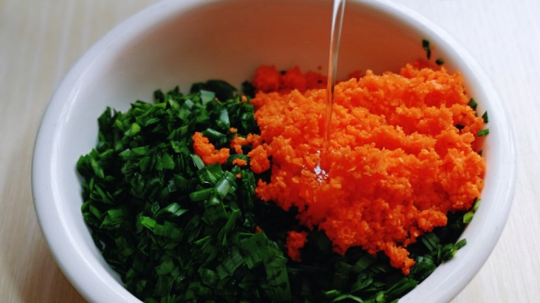 翡翠胡萝卜虾皮韭菜盒子,搅碎的胡萝卜加入放韭菜的器具中。