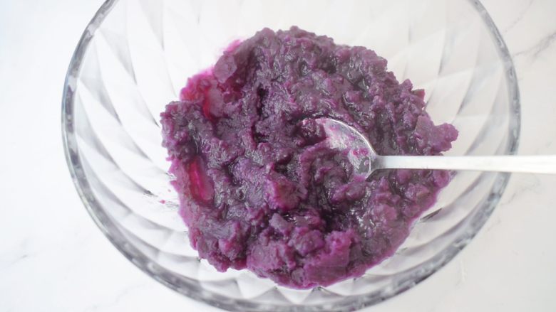 奶香紫薯饼,倒入容器中，用勺子把紫薯搅拌一下成泥状