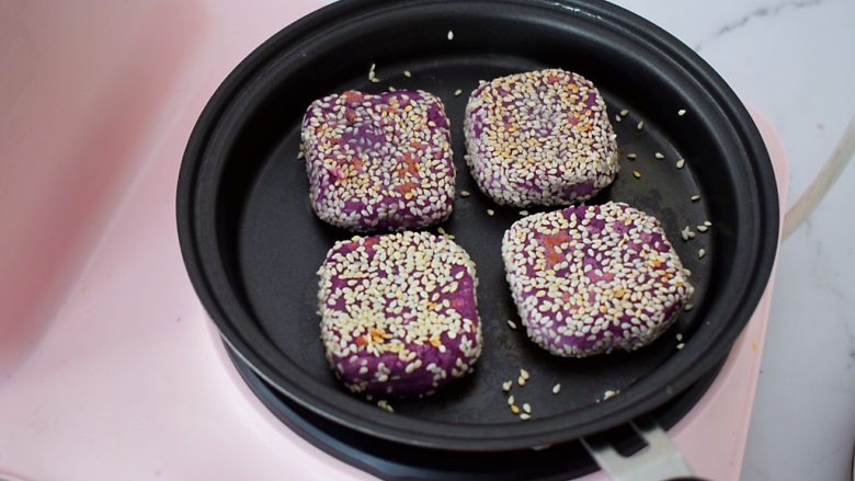奶香紫薯饼,翻面撒上1勺水，继续煎至水干，直至熟透后盛出即可