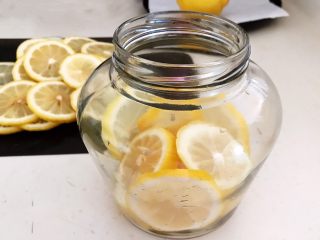 蜜渍柠檬皇菊茶,把柠檬片放入瓶中1/3，压实
