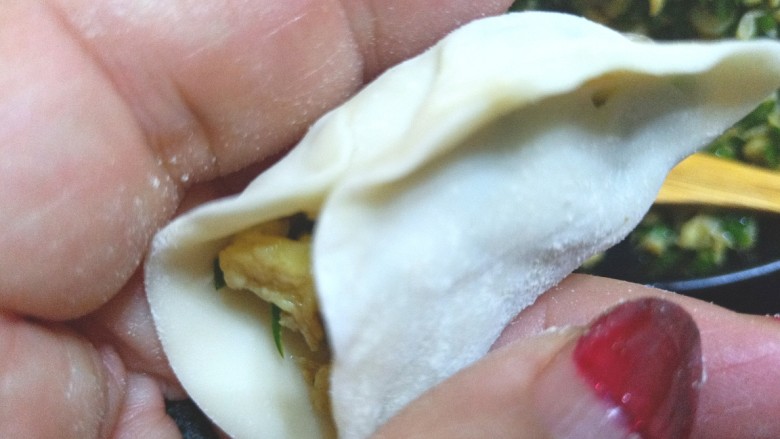 鸡蛋虾皮韭菜饺子,先把中间捏住，在把一边一点一点的捏在一起，在捏另一边。