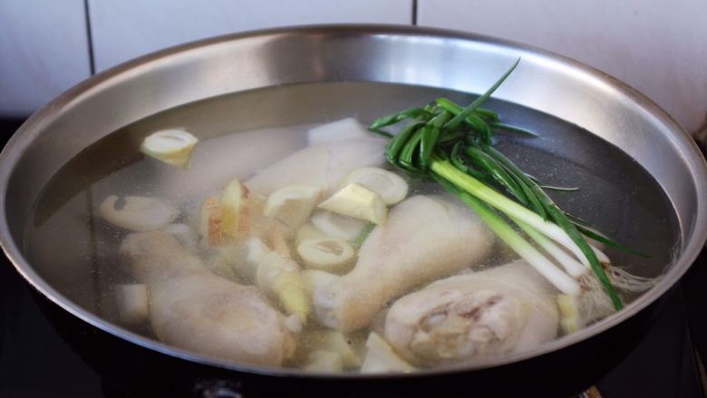 春笋海参煲鸡腿汤,大火置锅，温水或者开水放入春笋和鸡腿、小香葱、姜。