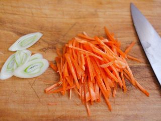 家常辣炒土豆丝,把葱切成薄片，胡萝卜切成丝。