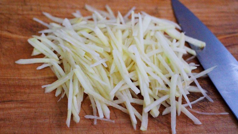 家常辣炒土豆丝,把去除外皮的土豆洗净后用刀切成丝，请忽略我的刀功。