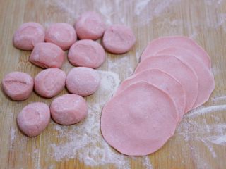 酸菜猪肉粉嫩饺子,把剂子用手摁扁，用擀面杖把剂子擀成圆形薄面皮。