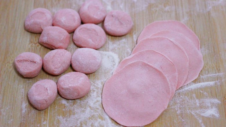 酸菜猪肉粉嫩饺子,把剂子用手摁扁，用擀面杖把剂子擀成圆形薄面皮。