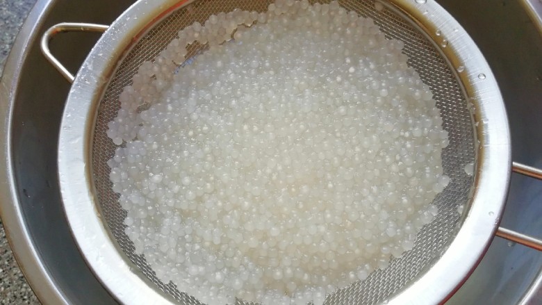 牛奶芒果西米露,焖好的小西米放在网筛里面用凉水冲洗几遍，沥干水分备用。
