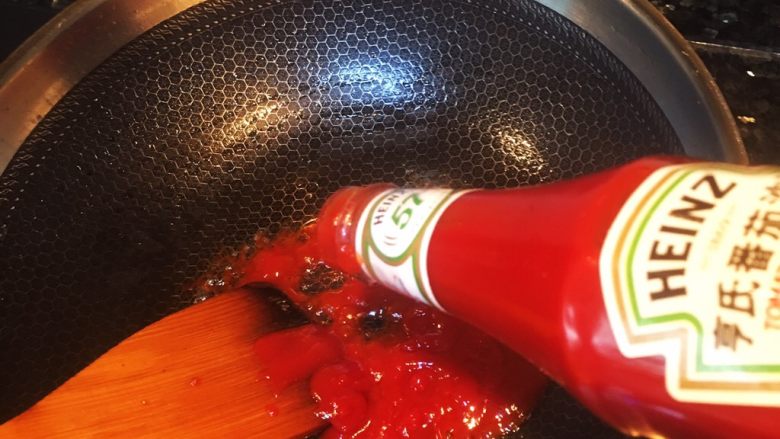 凤梨、菠萝咕噜肉,锅里加少许油加热，倒入大约3瓷勺的番茄沙司，炒匀。