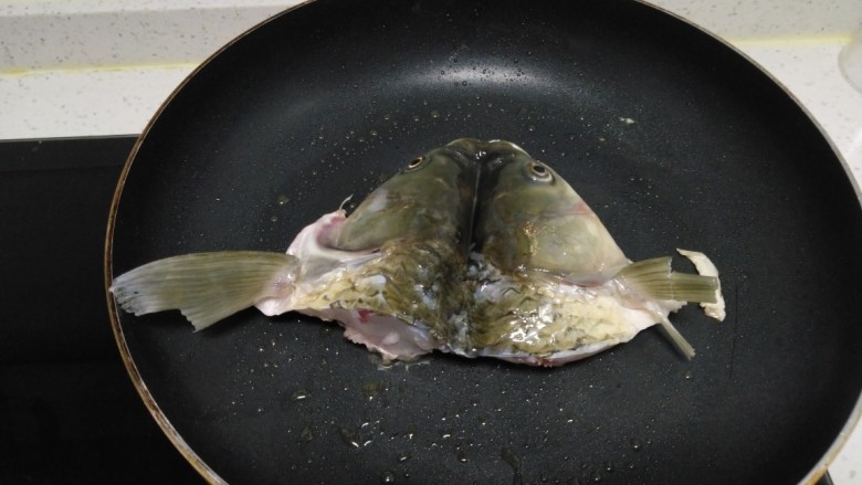 鱼头、豆腐炖韭菜,锅中放入适量油，放入鱼头。