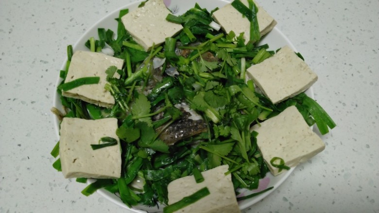 鱼头、豆腐炖韭菜,盛入盘中。
