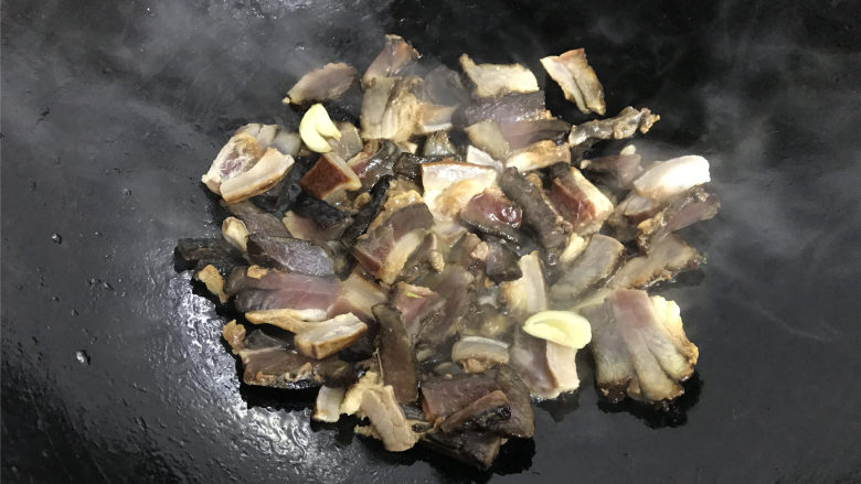 雷笋腊肉,把浸泡好的腊肉沥干水分后放入锅中，翻炒均匀后转中小火，把腊肉煸炒出油脂。