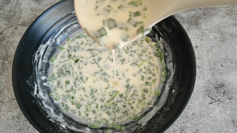 韭菜鸡蛋饼,面糊搅拌均匀后 舀一勺面糊可以像线一样低落即可 如图所示。