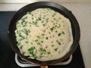 韭菜鸡蛋饼,锅内刷一层底油 倒入一勺面糊摊平。