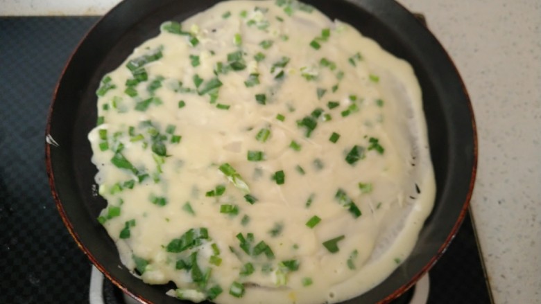 韭菜鸡蛋饼,锅内刷一层底油 倒入一勺面糊摊平。