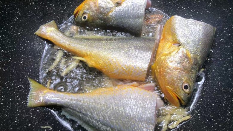 酸菜炖黄鱼,锅里放入适量油，烧至8成热，把姜丝放入爆香，再把黄鱼放入煎制。