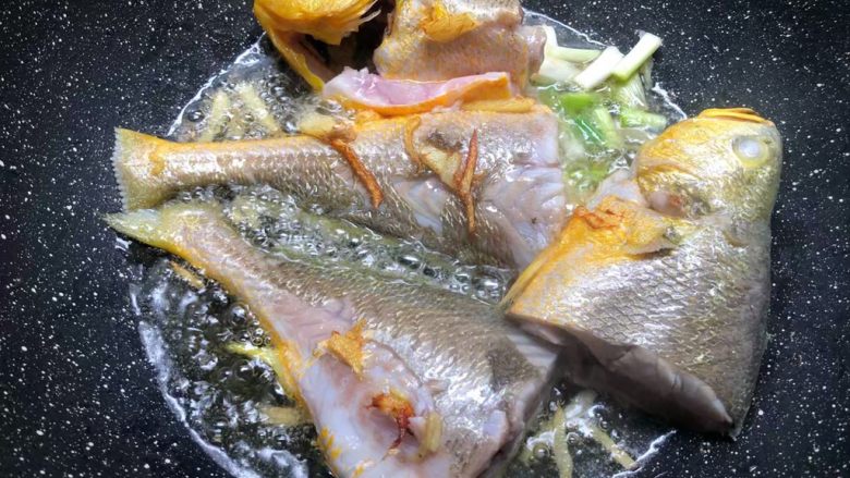 酸菜炖黄鱼,煎好一面翻另一面继续煎制，待两面煎好以后，放入葱白爆香。