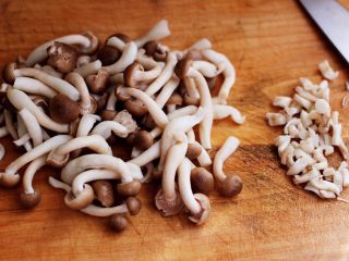 蟹味菇爆花肉,蟹味菇洗净后，用刀把蟹味菇的根部去掉不用。