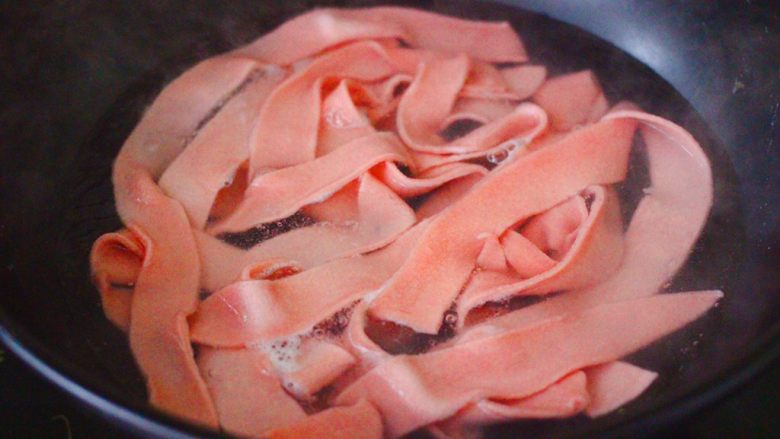 黄瓜牛肉粉嫩扯面,锅中倒入适量的清水煮沸后，把做好的面皮放入锅中煮熟捞出沥干水分。