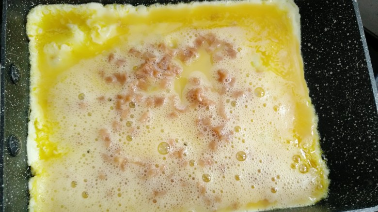 菜脯蛋卷,取三分之一的蛋液倒入煎锅