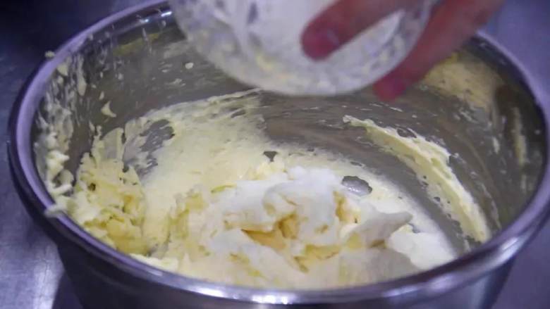 奶香曲奇饼干,将面粉放入筛子中过筛后，加入之前的黄油糊中，搅拌均匀至顺滑无明显的颗粒；
