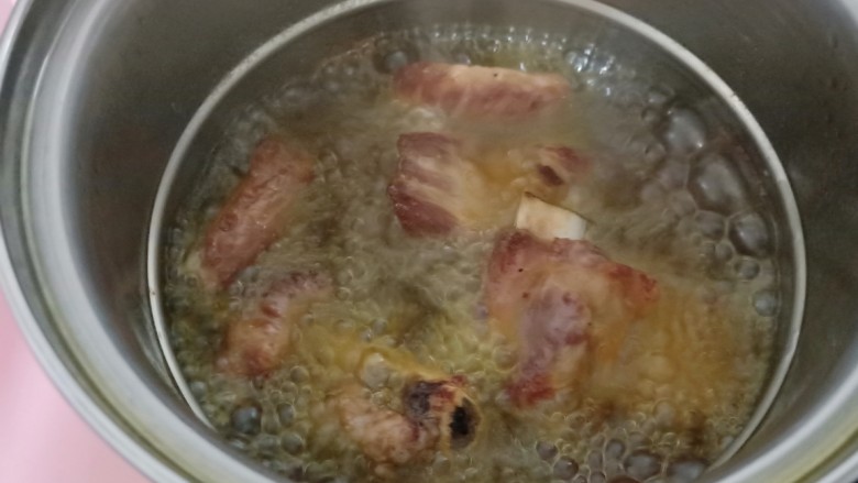 金牌本帮糖醋排骨,油温烧至6-7成热时把腌制好的肋排下锅中开炸。