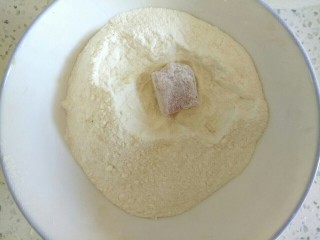 菠萝咕咾肉,准备适量面粉，把猪肉在面粉中滚一下，粘满面粉