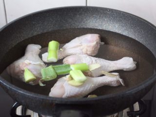春天的美味 腌笃鲜（鸡肉版）,凉水下鸡腿，焯水。
焯水时水里放2片姜、2段葱。