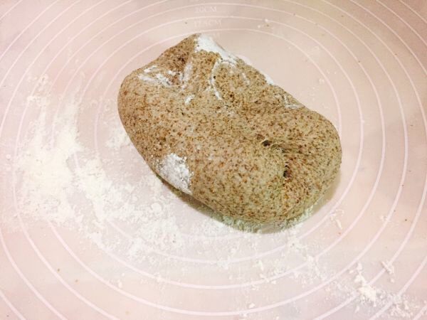超萌黑全麦粉小熊馒头,在案板上撒点面粉，将发酵好的面团揉搓排出空气
