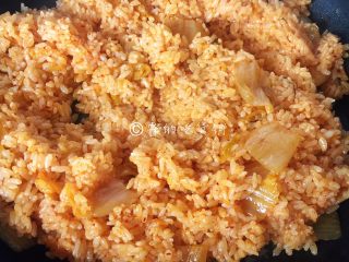 泡菜金枪鱼炒饭,一直炒到米饭变得松散、粒粒分明了，泡菜汁均匀的米饭全都包裹住。