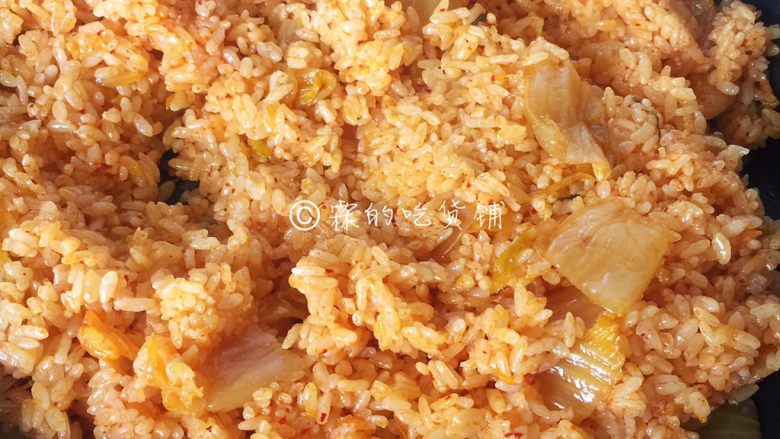 泡菜金枪鱼炒饭,一直炒到米饭变得松散、粒粒分明了，泡菜汁均匀的米饭全都包裹住。