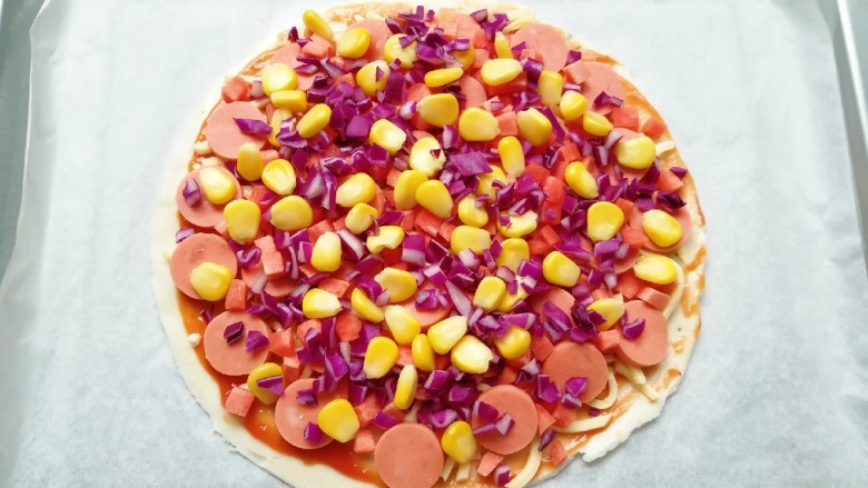 手抓饼披萨,均匀的撒上玉米粒、红萝卜和紫甘蓝。