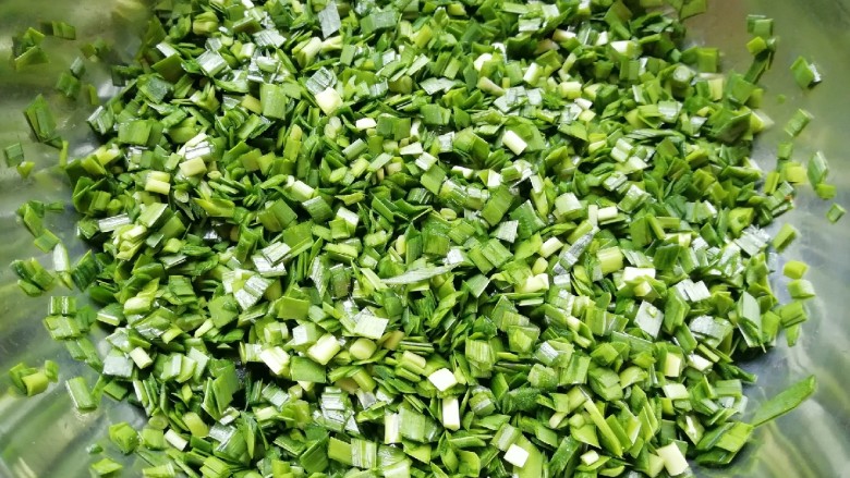 干拌饺子,控过水的韭菜切碎放入盆里，加入熟油搅拌均匀。
