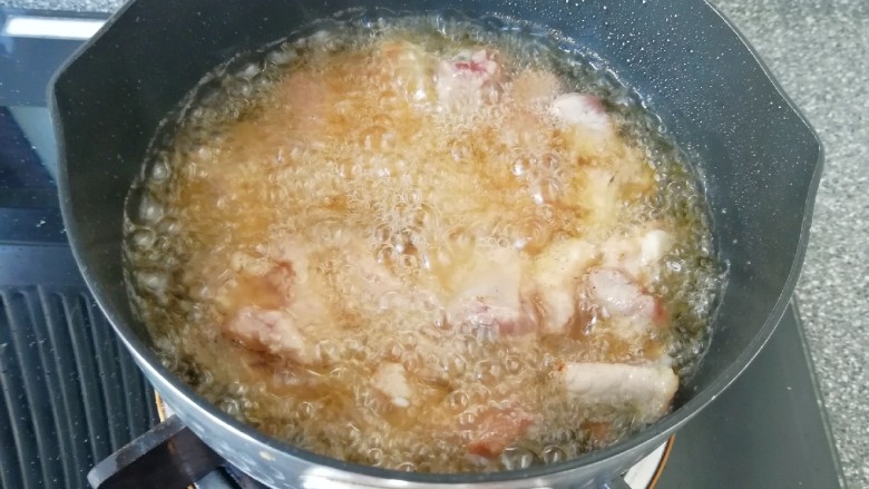金牌本帮糖醋排骨,油温烧至6–7成热时，把腌制好的排骨下入锅中开始炸制。