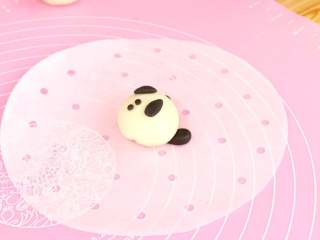 熊猫豆包,眼睛部位粘上黑色压扁的雨滴状，压扁的小黑点装饰鼻子和嘴

