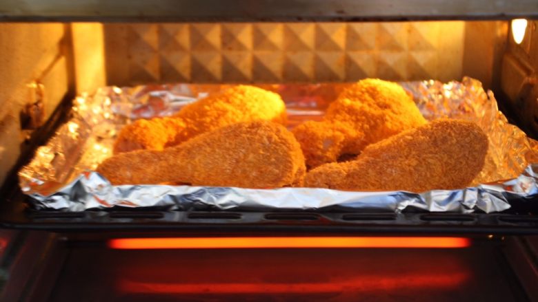 烤奥尔良风味黄金鸡腿,将烤盘放入烤箱中层。
